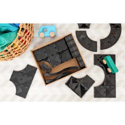 Wooden box containing dark-colored tangram puzzle pieces.