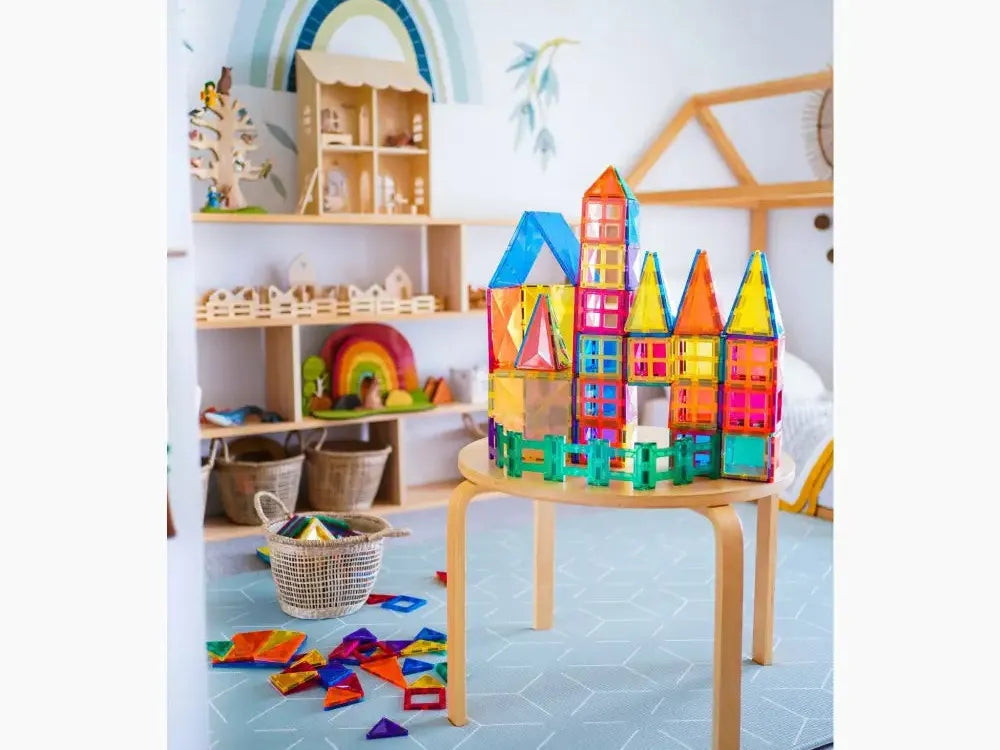 Colorful magnetic tile construction set forming a castle-like structure on a wooden table.