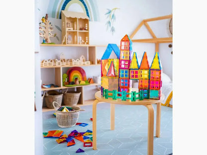 Colorful magnetic tile construction set forming a castle-like structure on a wooden table.