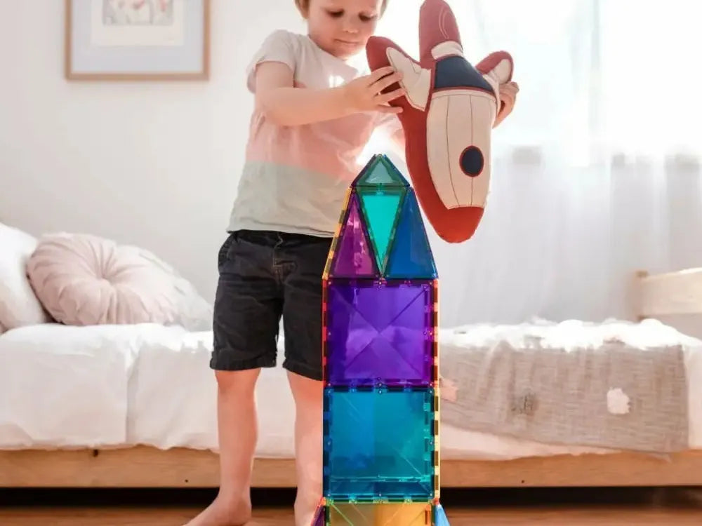 Colorful magnetic building tiles stacked into a tall rocket-like structure with a decorative top piece.