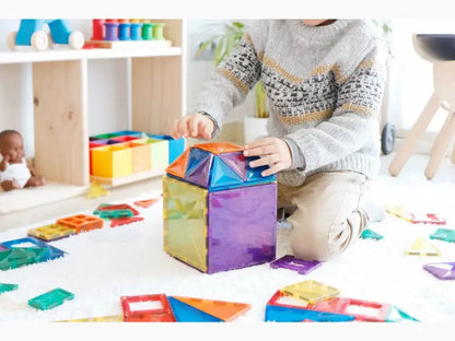 Colorful magnetic building tiles being assembled by a child’s hands.