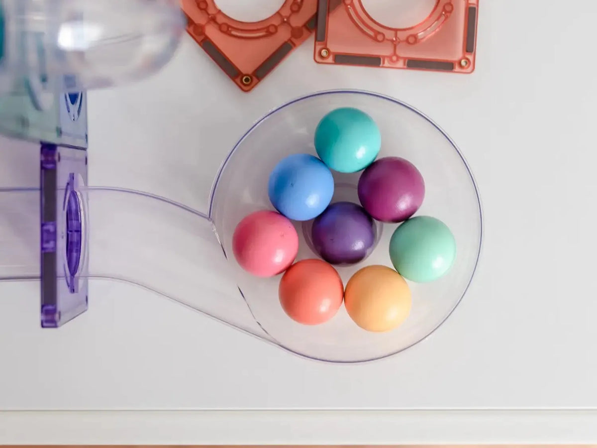 Colorful Easter eggs arranged in a circular pattern on a clear plate.