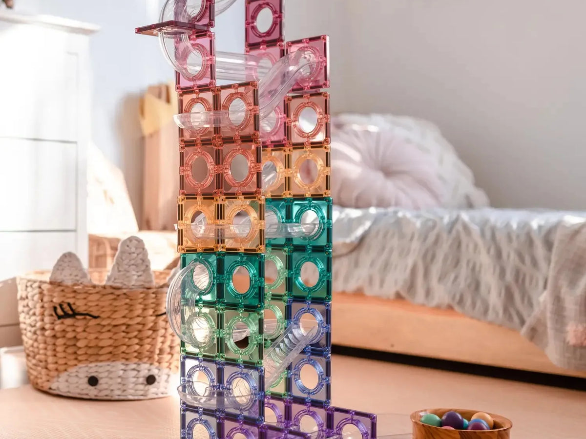 Colorful magnetic building tiles stacked into a tall structure.