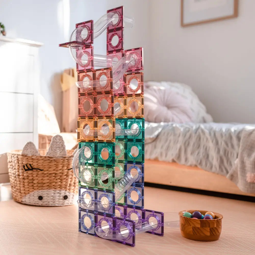 Colorful magnetic building tiles stacked into a tall structure.