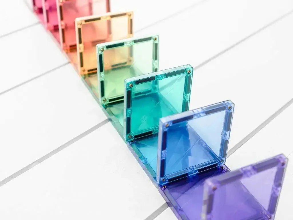 Rainbow-colored, transparent acrylic or glass squares arranged in a diagonal line.