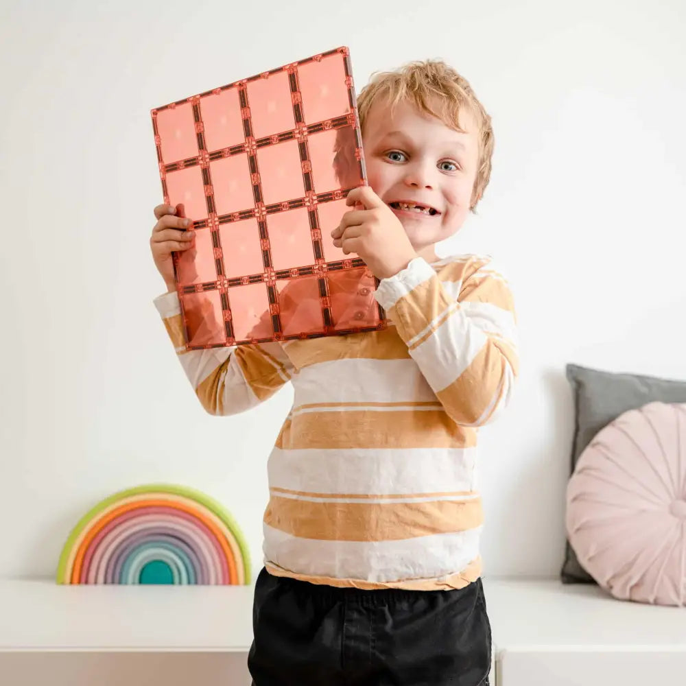 Smiling child holding a giant chocolate bar-shaped object.