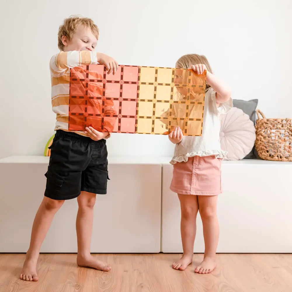 Colorful interlocking wooden block set held by two children.