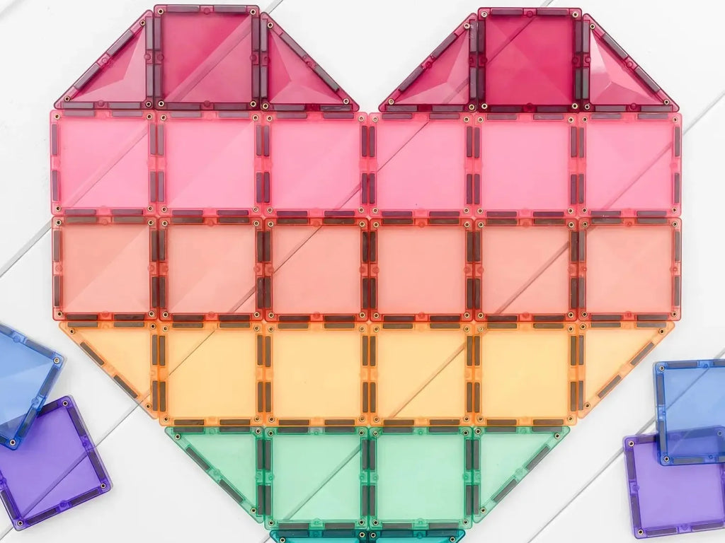 Heart-shaped arrangement of colorful, translucent geometric tiles in rainbow order.