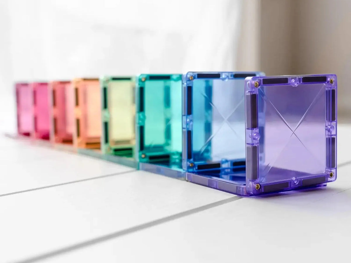 Row of colorful translucent cube-shaped objects arranged in a rainbow spectrum.