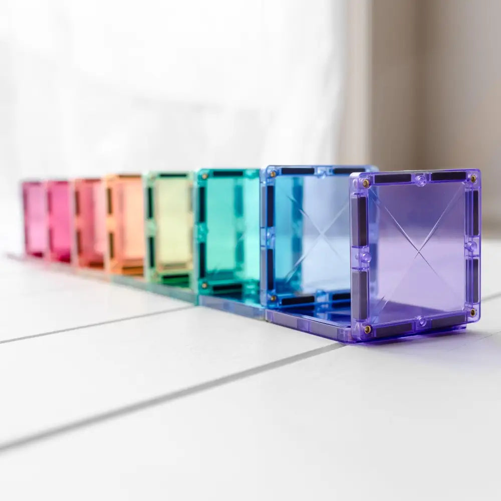 Row of colorful translucent cube-shaped objects arranged in a rainbow spectrum.