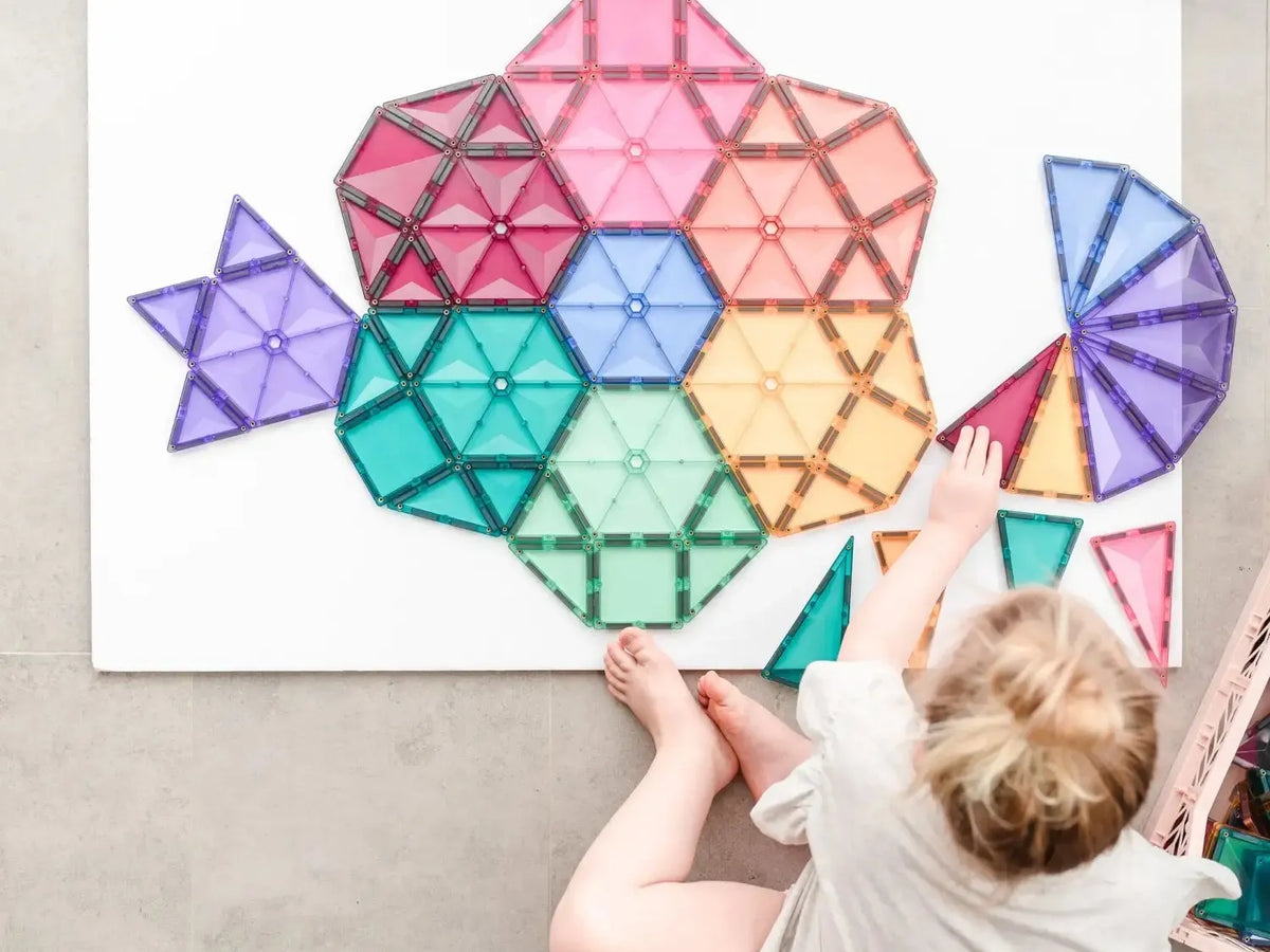 Colorful geometric shapes arranged in a flower-like pattern on a white surface.