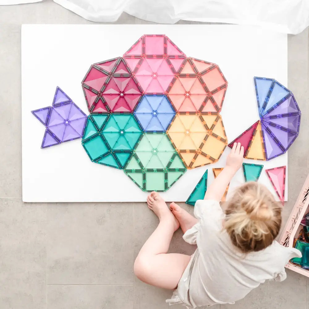 Colorful geometric shapes arranged in a flower-like pattern on a white surface.