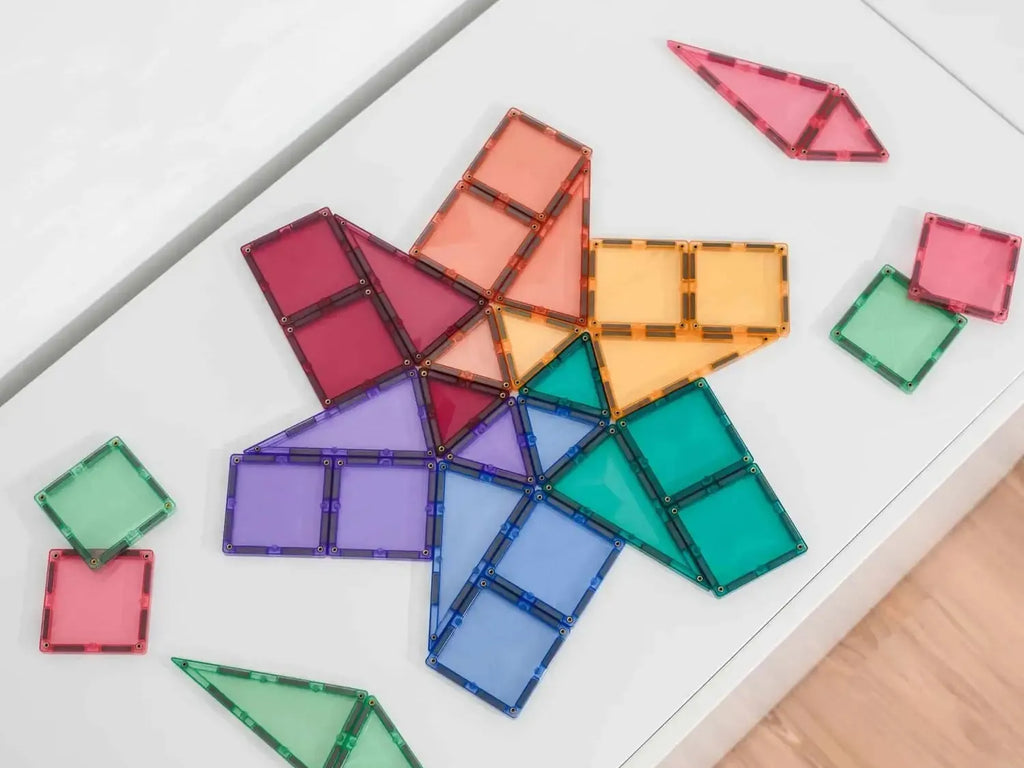 Colorful magnetic geometric shapes arranged in a star-like pattern on a white surface.