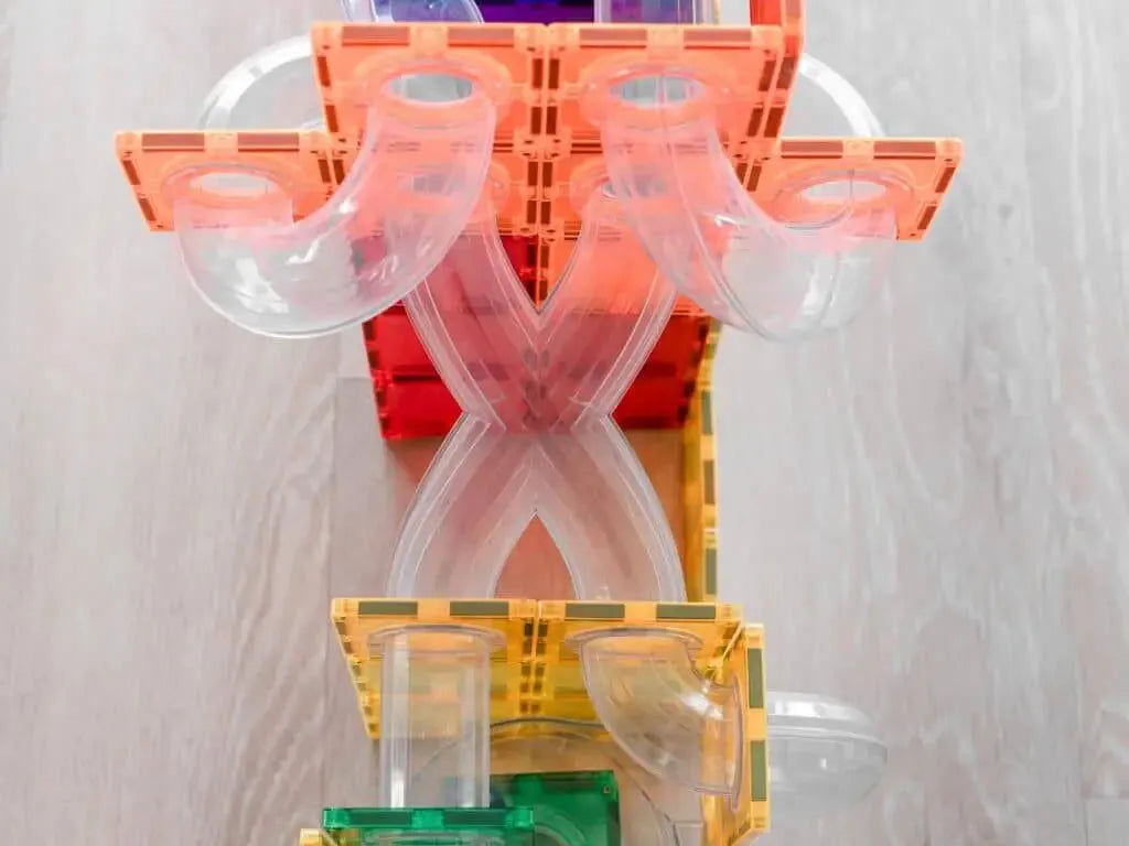 Colorful plastic construction toy or marble run with interconnected pieces and tubes.