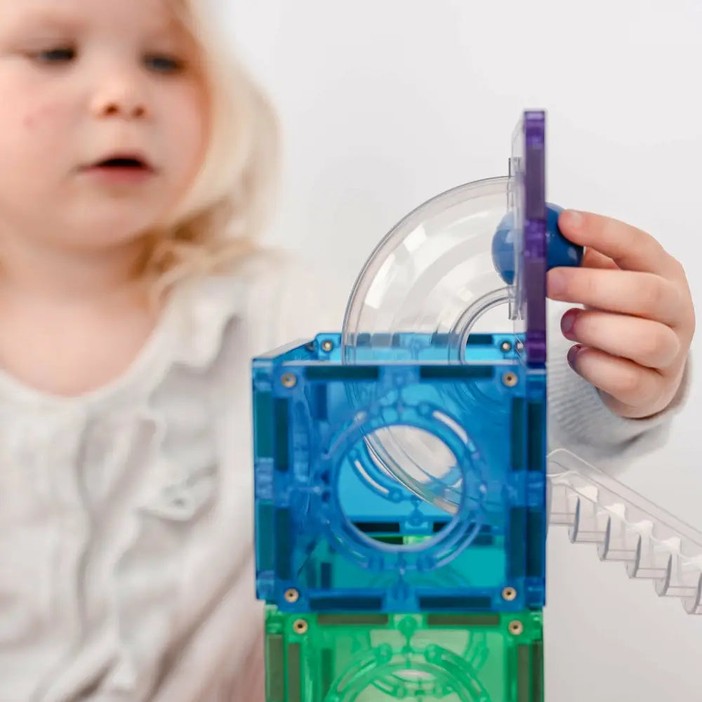 Colorful plastic toy with interconnected chambers and tubes for exploring air or ball movement.