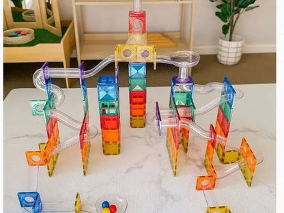 Colorful magnetic tile construction set with various shapes and pieces arranged on a surface.