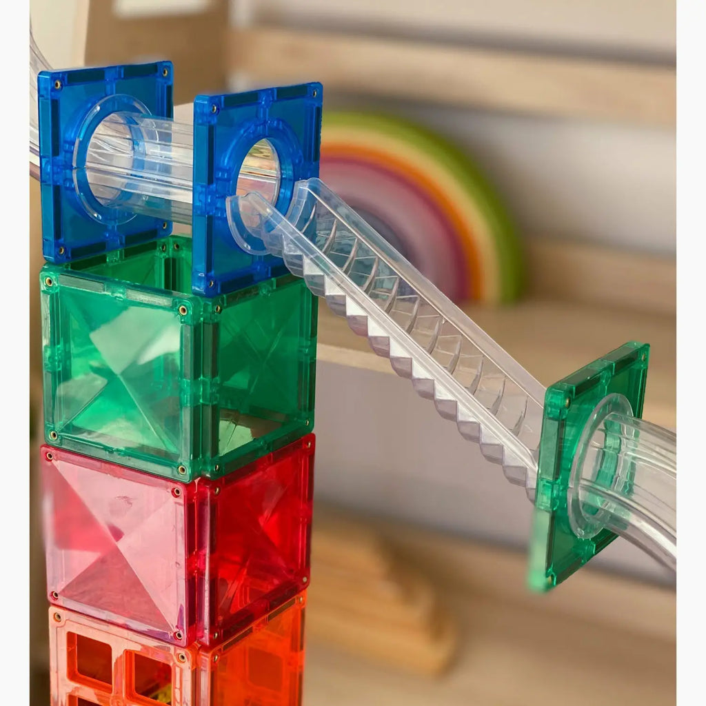 Colorful plastic building blocks with a transparent tube and staircase attachment.