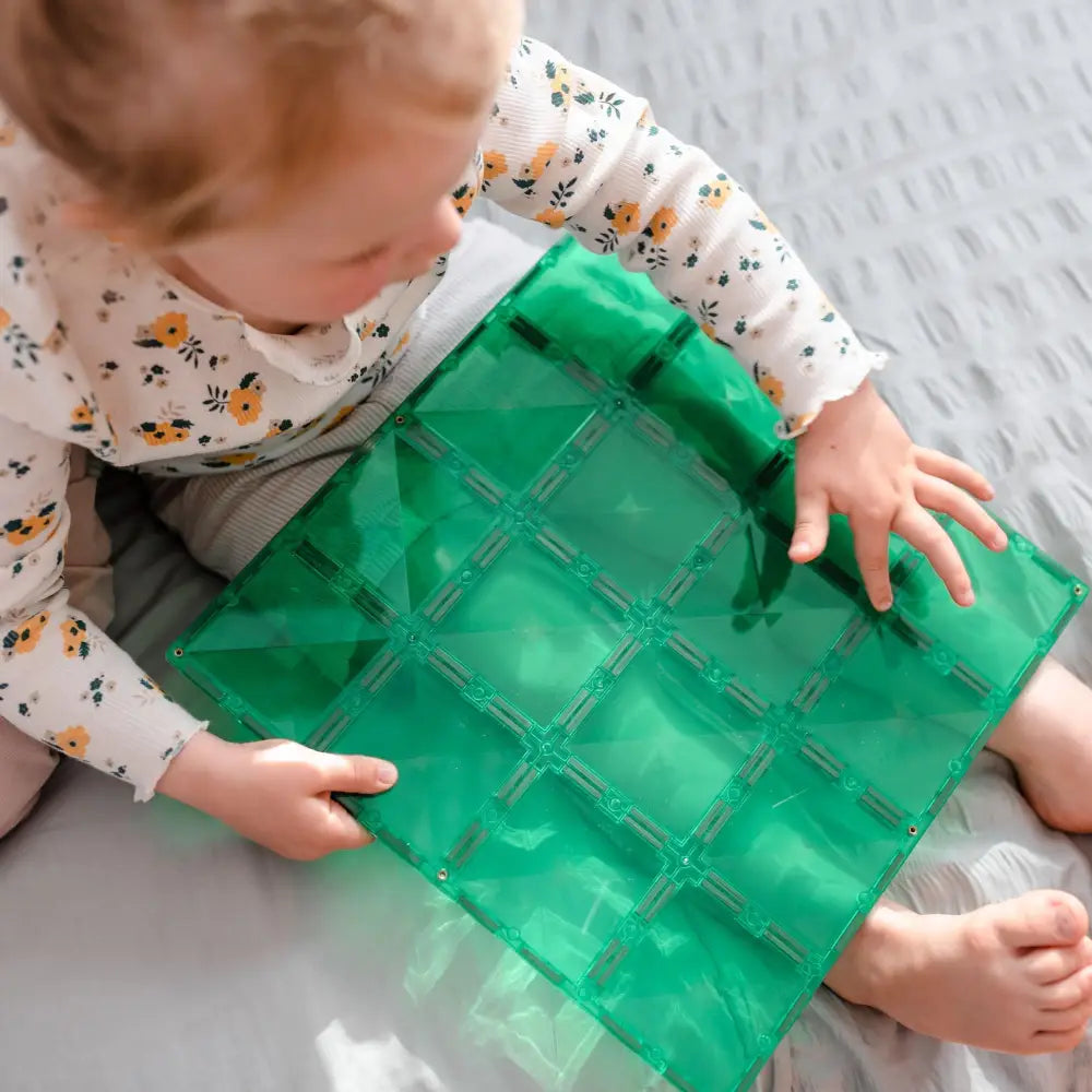 Green sensory mat with square-shaped compartments filled with liquid.