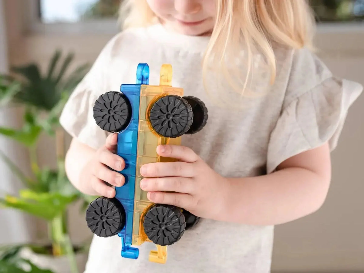 A colorful toy car or vehicle with black wheels held by small hands.