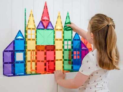 Colorful magnetic building tiles arranged into a castle-like structure on a wall.