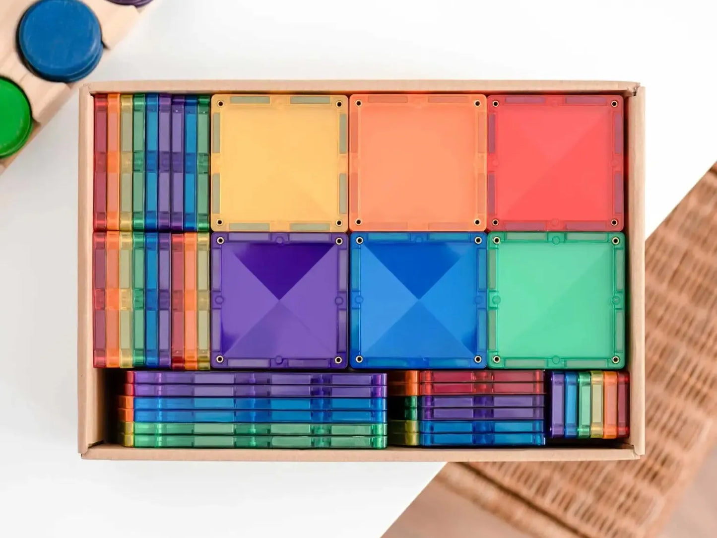 Colorful wooden geometric shape sorting toy set in a rectangular box.