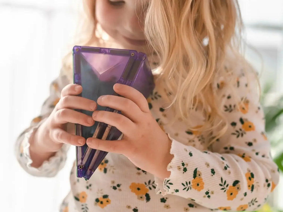 Purple tablet or e-reader device held by hands in a floral-patterned sleeve.