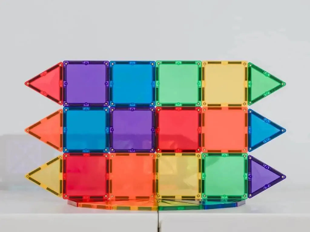 Colorful magnetic building tiles arranged in a rectangular shape with arrow-like ends.