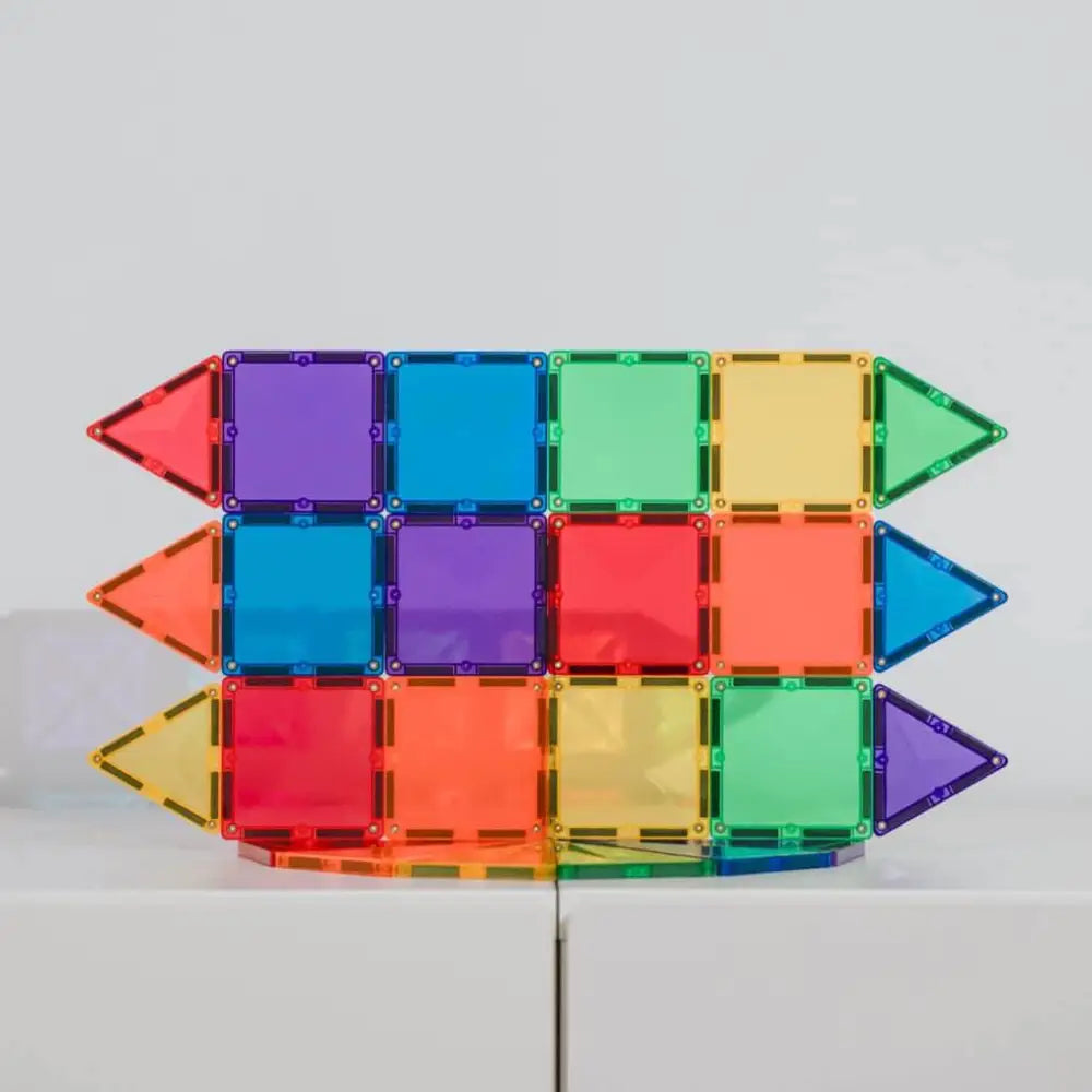 Colorful magnetic building tiles arranged in a rectangular shape with arrow-like ends.