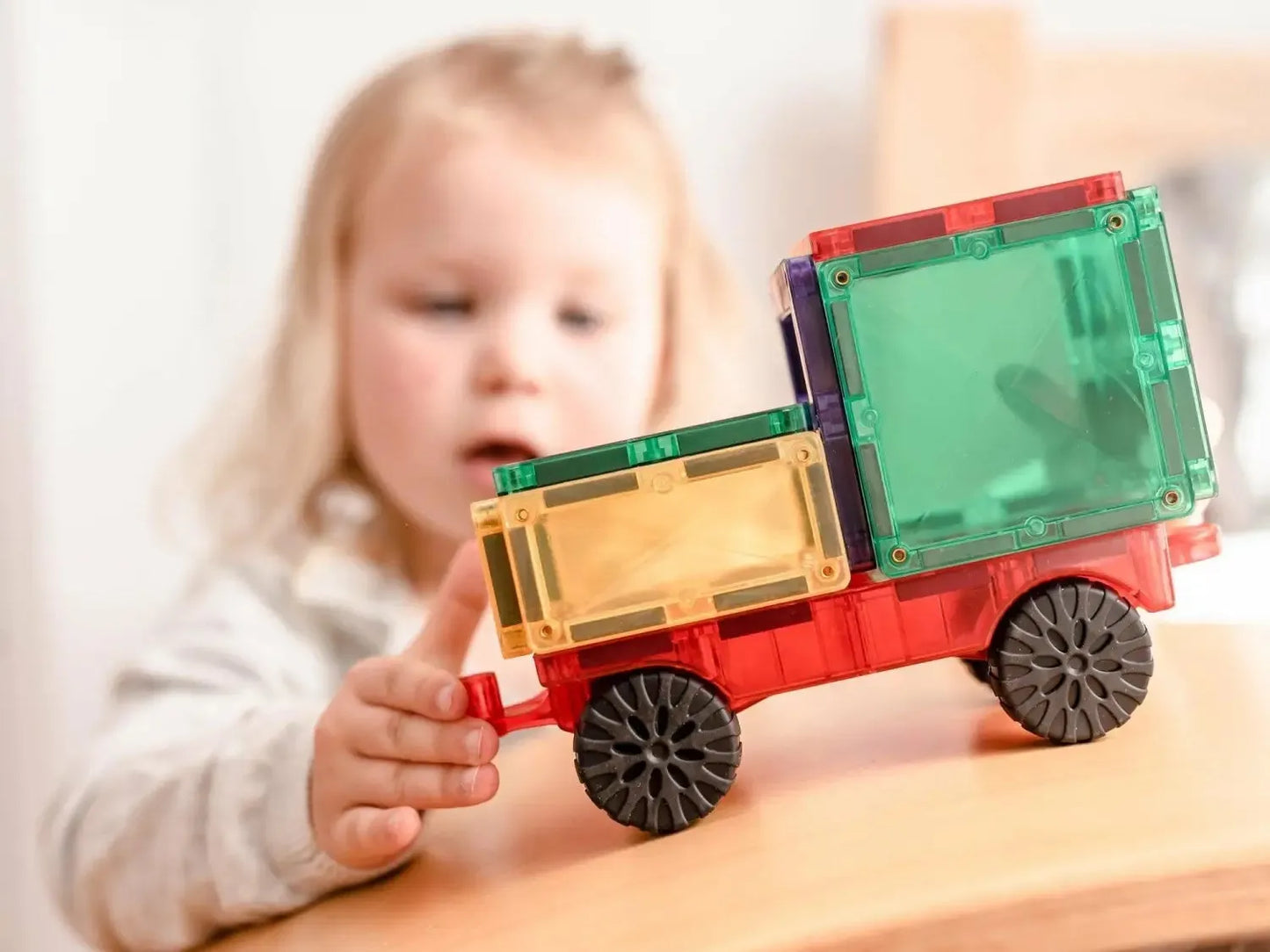 Colorful toy truck with transparent plastic blocks forming the cargo area.