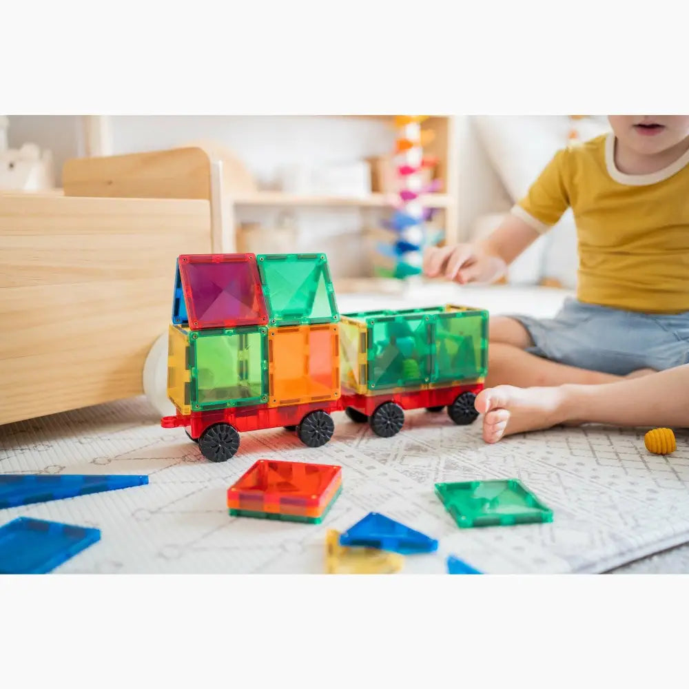 Colorful magnetic building tiles assembled into a toy train shape.