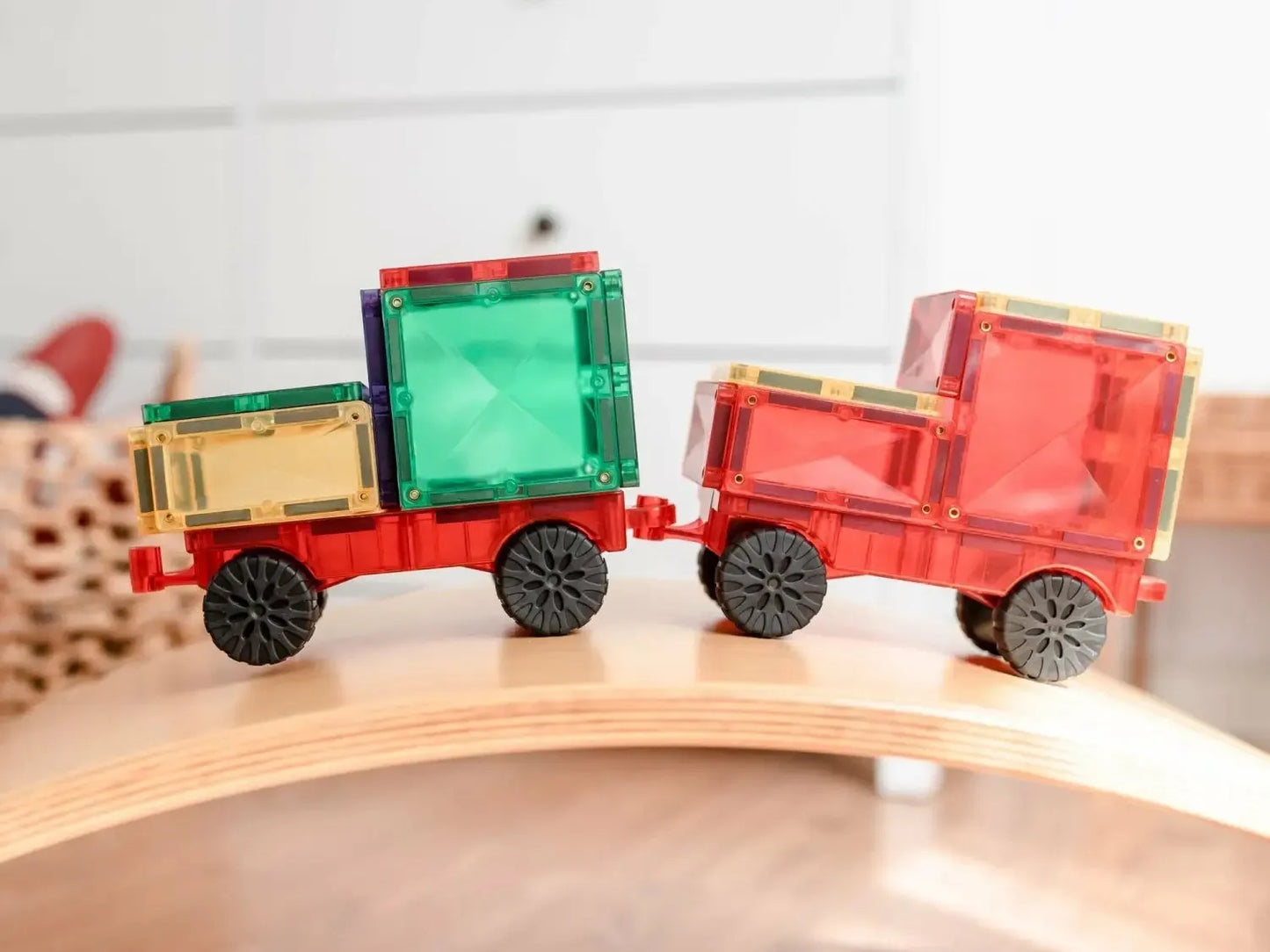 Colorful toy train made of transparent plastic blocks on a curved wooden track.