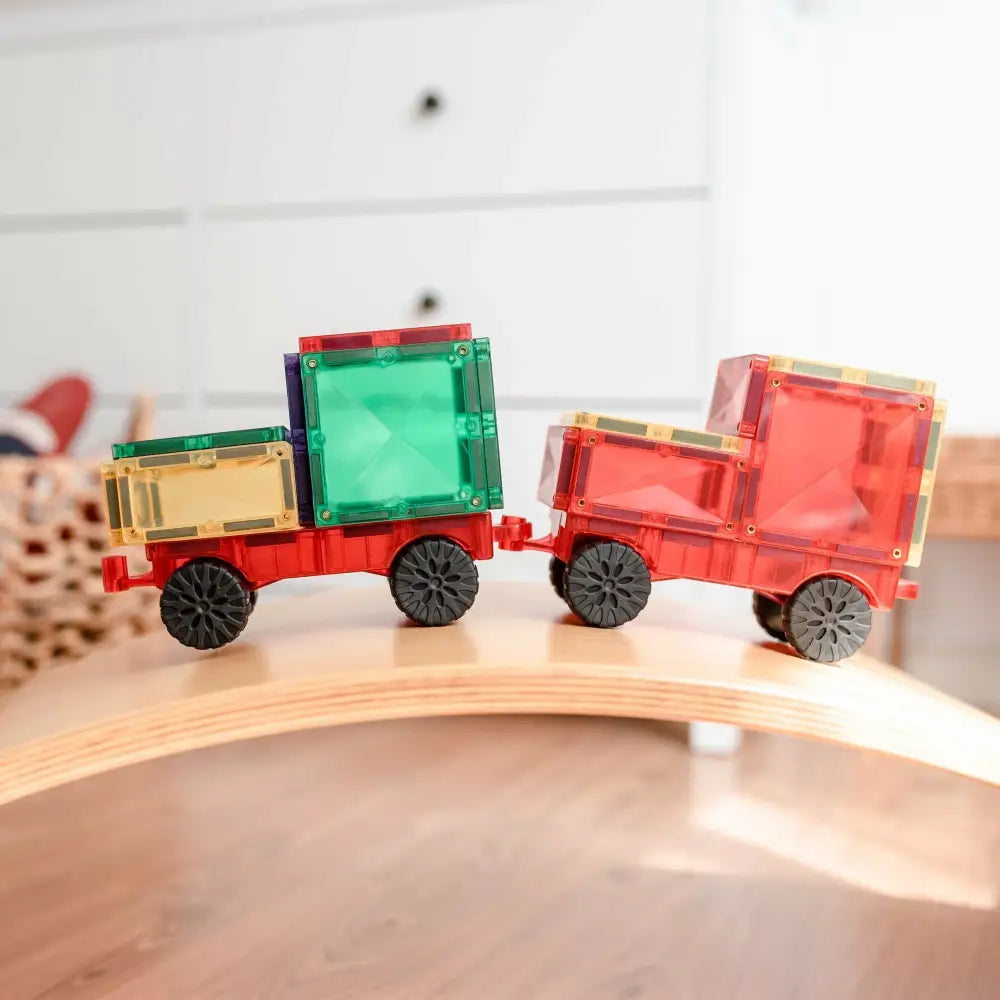 Colorful toy train made of transparent plastic blocks on a curved wooden track.