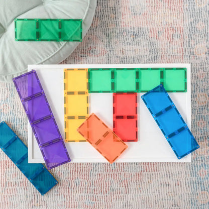 Colorful plastic building blocks or tiles arranged on a white surface.
