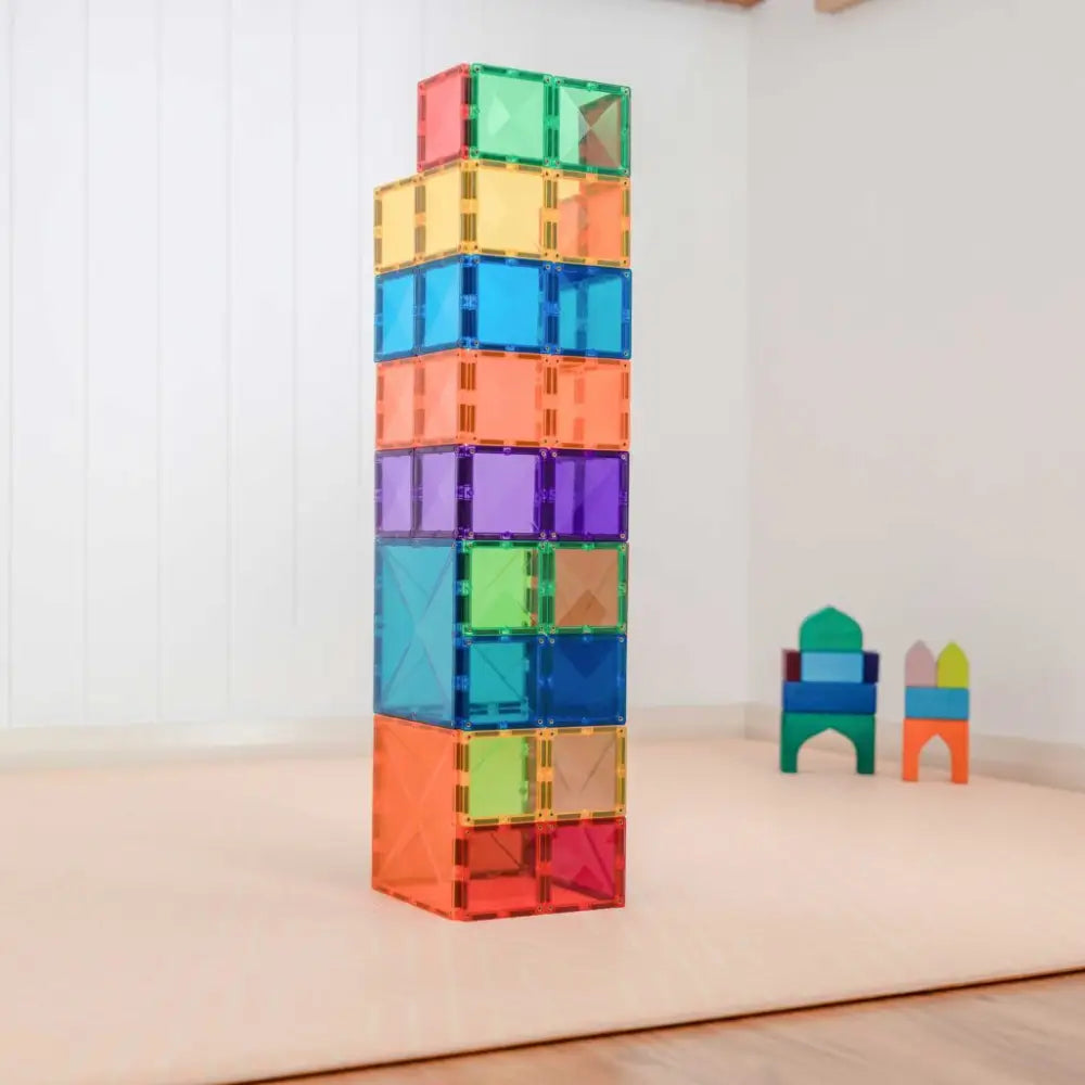 Colorful stack of transparent magnetic building tiles forming a tall tower.