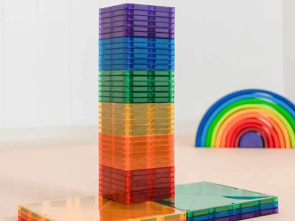 Colorful stack of transparent magnetic building tiles in rainbow colors.