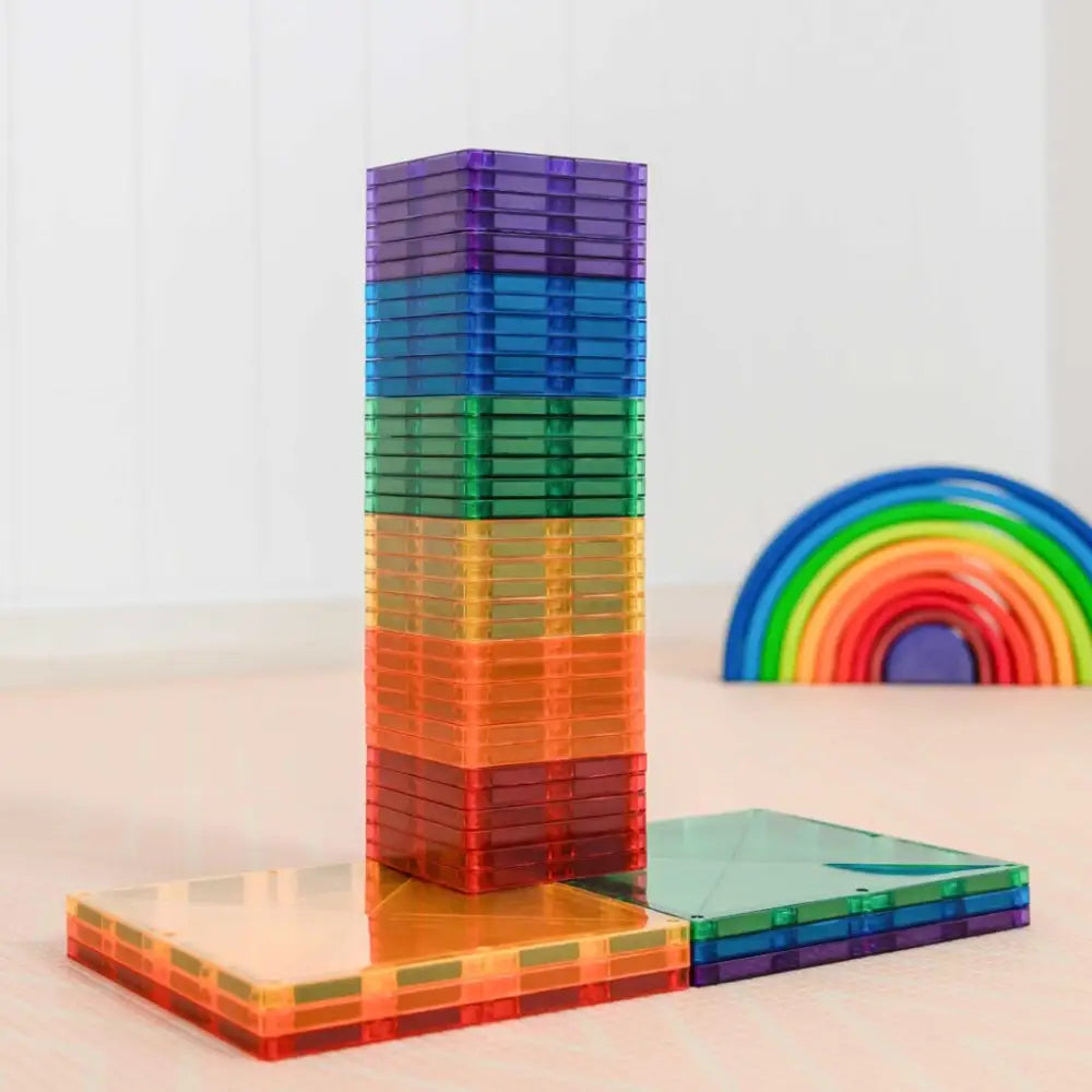 Colorful stack of transparent magnetic building tiles in rainbow colors.