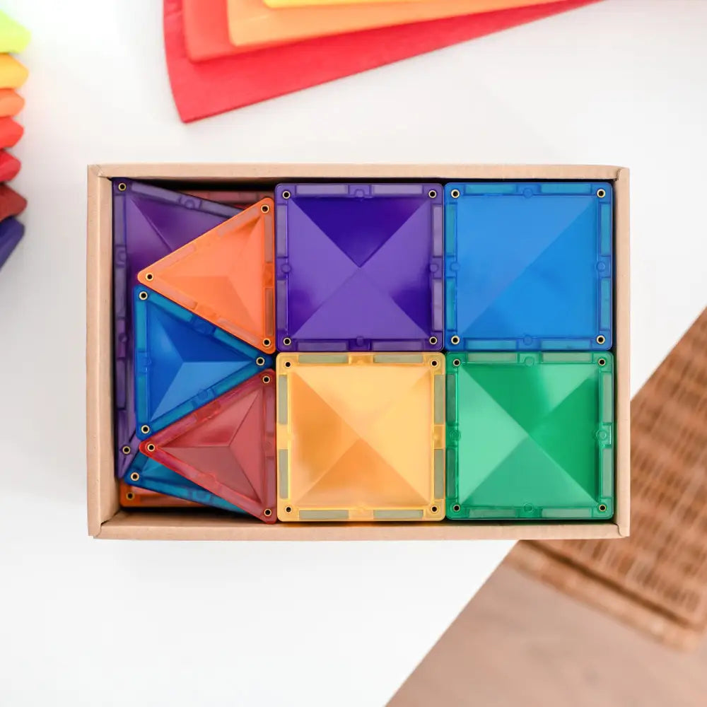 Wooden box containing colorful geometric magnetic tiles in various shapes and sizes.