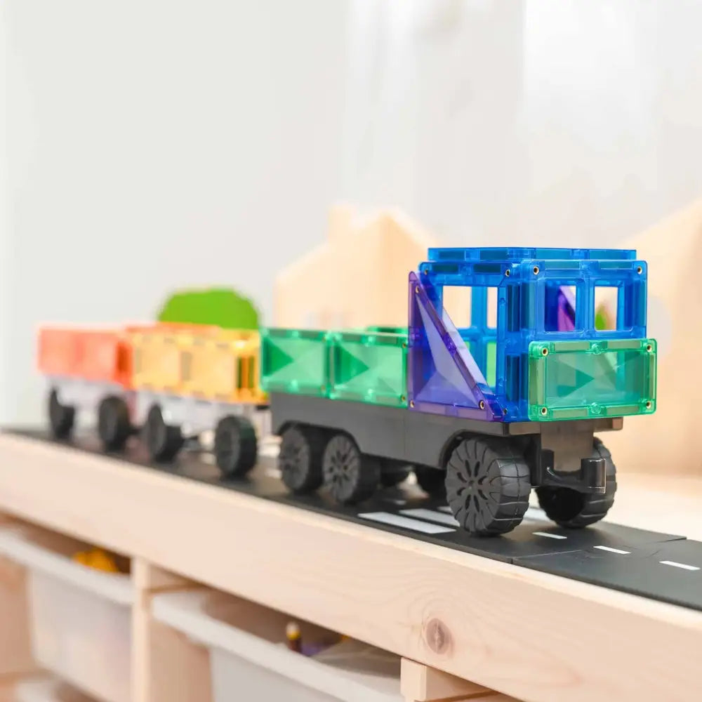 Colorful toy train made of magnetic building blocks on a track.