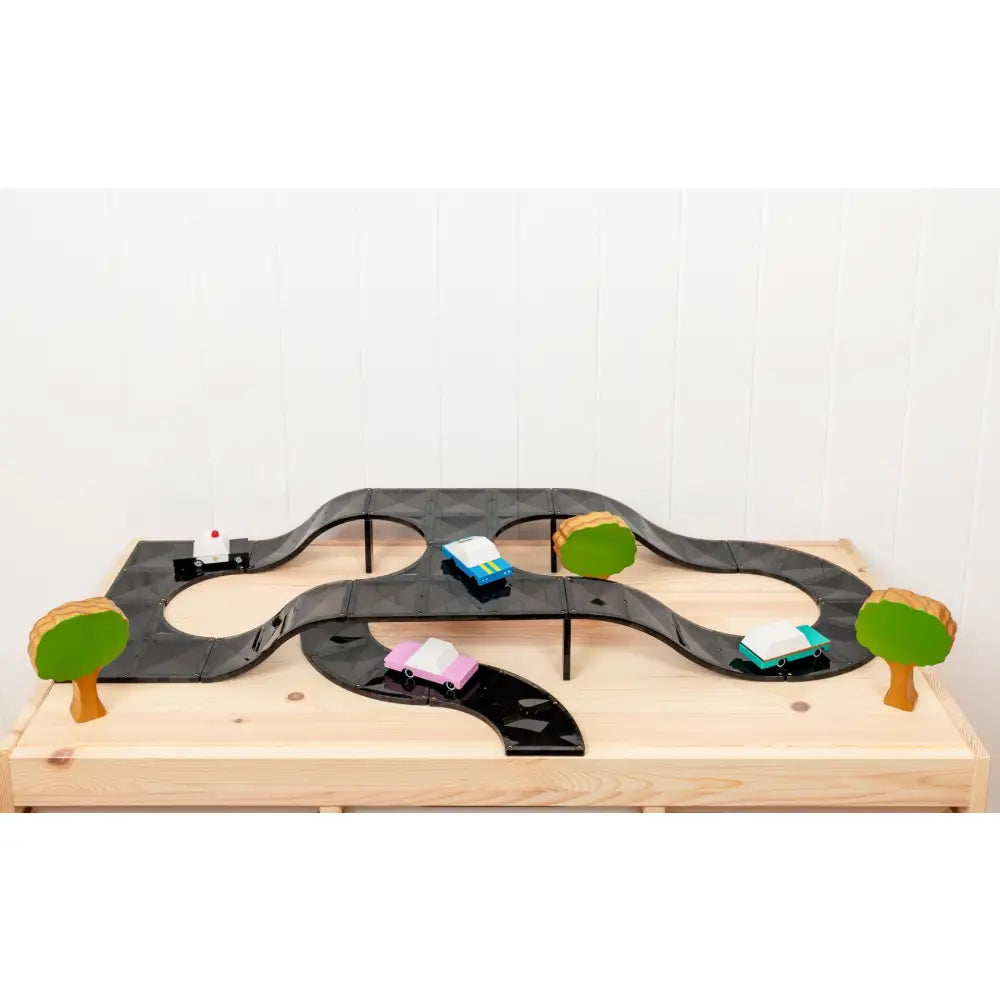 Wooden toy car track with miniature vehicles and trees.