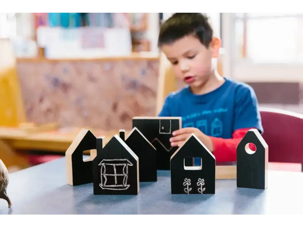Black wooden house-shaped blocks on a table.