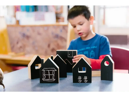 Black wooden house-shaped blocks on a table.