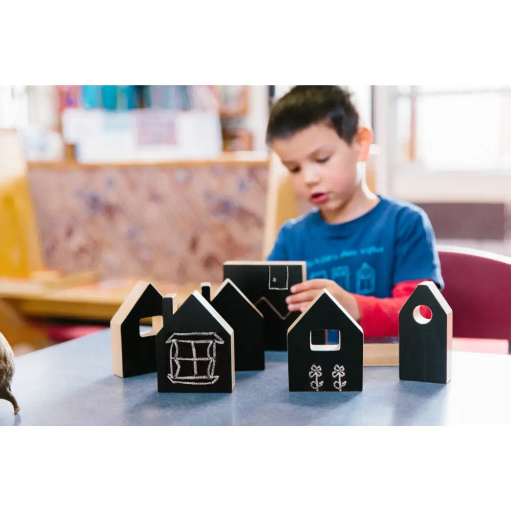 Black wooden house-shaped blocks on a table.