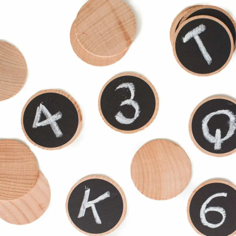 Wooden discs with chalkboard surfaces displaying numbers and letters.