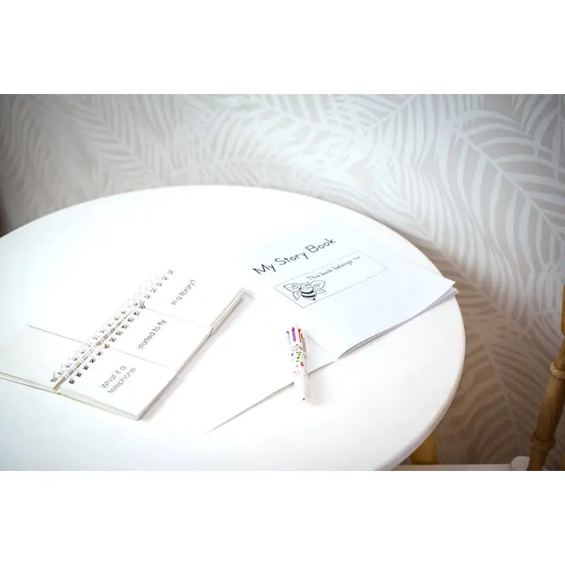 White circular table with wedding planning documents and a pen.