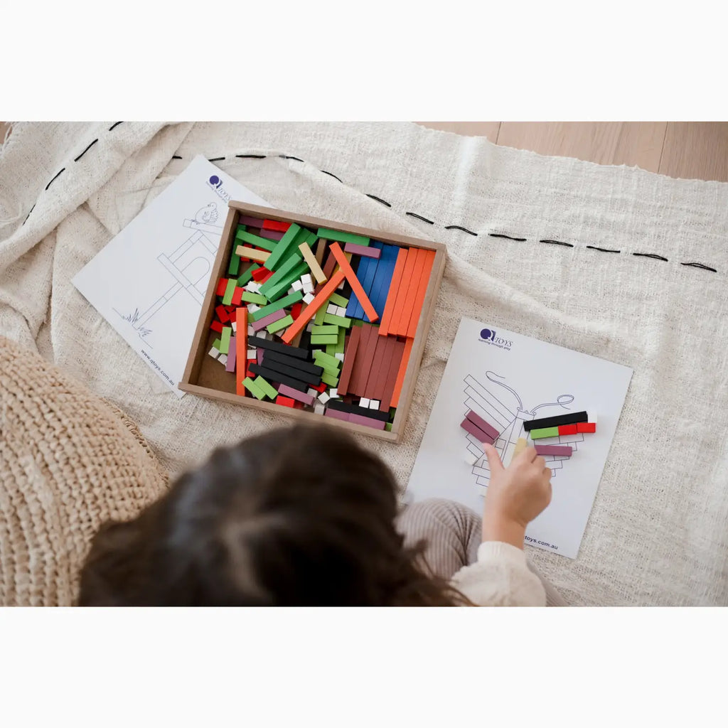 Colorful wooden counting rods in a wooden box with instruction sheets.