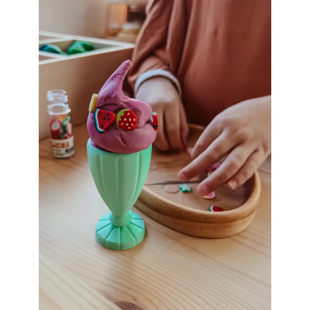 Colorful plastic ice cream sundae toy with a pink top and green base.