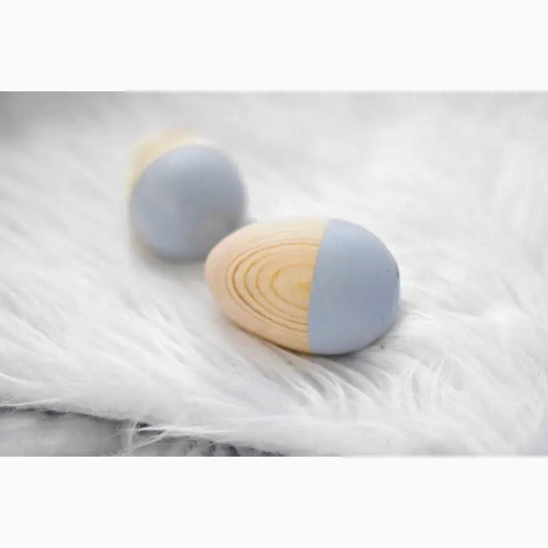 Two-toned wooden eggs, half painted in pale blue.