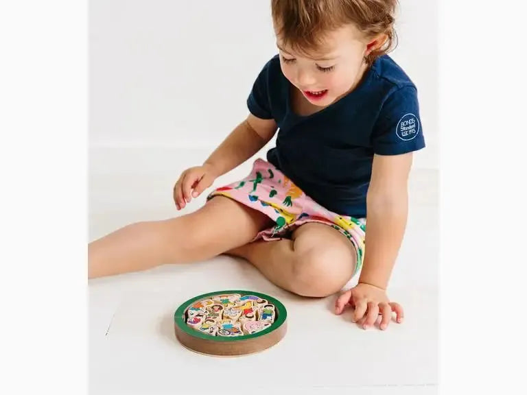 Young child playing with a colorful wooden puzzle or game board.
