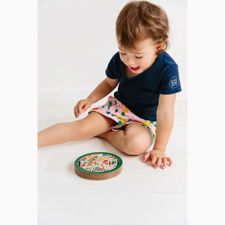 Young child playing with a colorful wooden puzzle or game board.