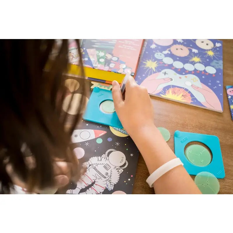 Child’s hand drawing or coloring on a space-themed illustration.